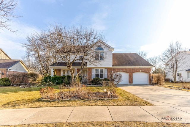 traditional-style house with a front yard, concrete driveway, brick siding, and an attached garage