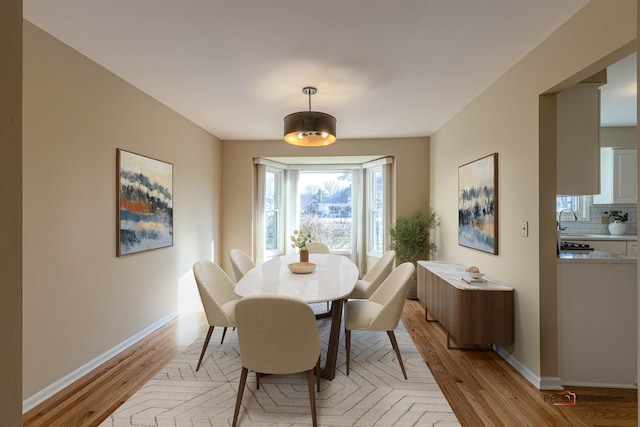 dining room with light wood-style flooring and baseboards