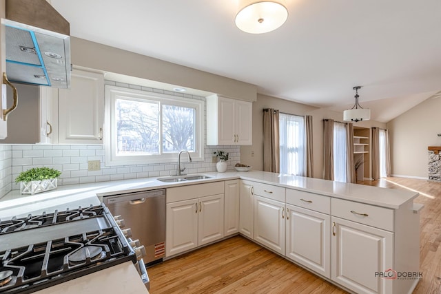 kitchen with dishwasher, a sink, gas range, and light wood-style floors