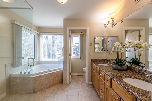 full bathroom featuring tile patterned flooring, a garden tub, a sink, and toilet