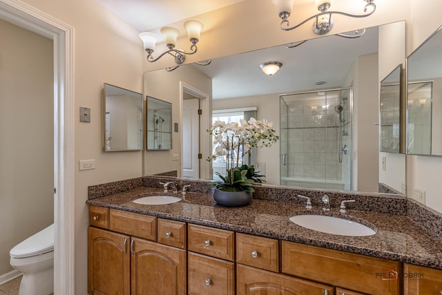 full bathroom with tiled shower, a sink, toilet, and double vanity