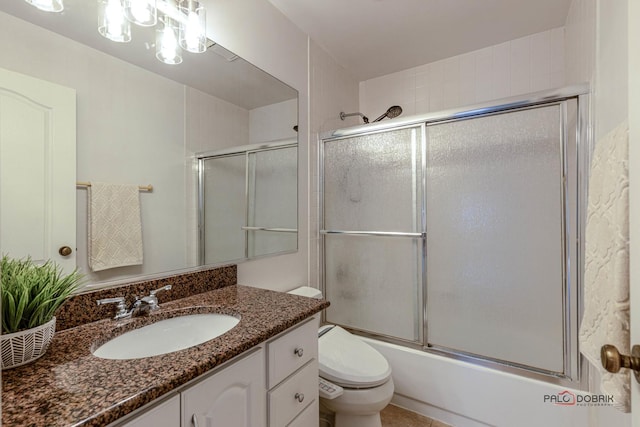 bathroom with toilet, bath / shower combo with glass door, and vanity