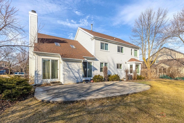 back of property featuring a patio, a lawn, a chimney, and roof with shingles