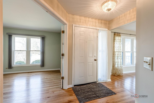 foyer featuring light wood-style floors and baseboards