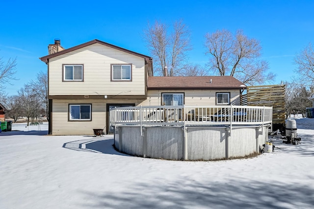 snow covered rear of property featuring a wooden deck