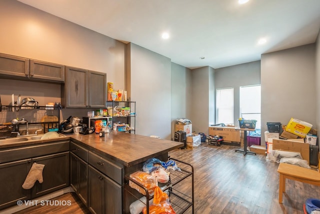 kitchen featuring sink, dark brown cabinets, dark hardwood / wood-style floors, and kitchen peninsula