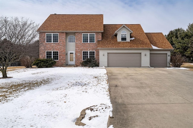 colonial-style house with driveway, roof with shingles, and an attached garage