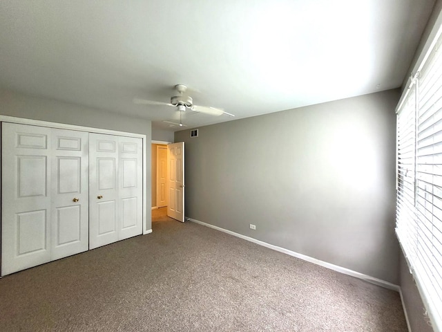 unfurnished bedroom with a closet, carpet flooring, and ceiling fan