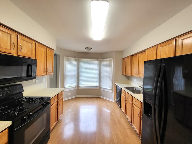 kitchen featuring sink, black appliances, and light wood-type flooring