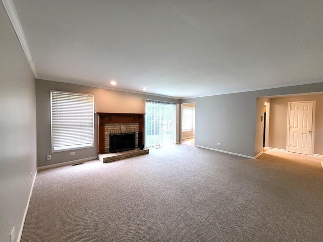 unfurnished living room with a fireplace, crown molding, and light carpet