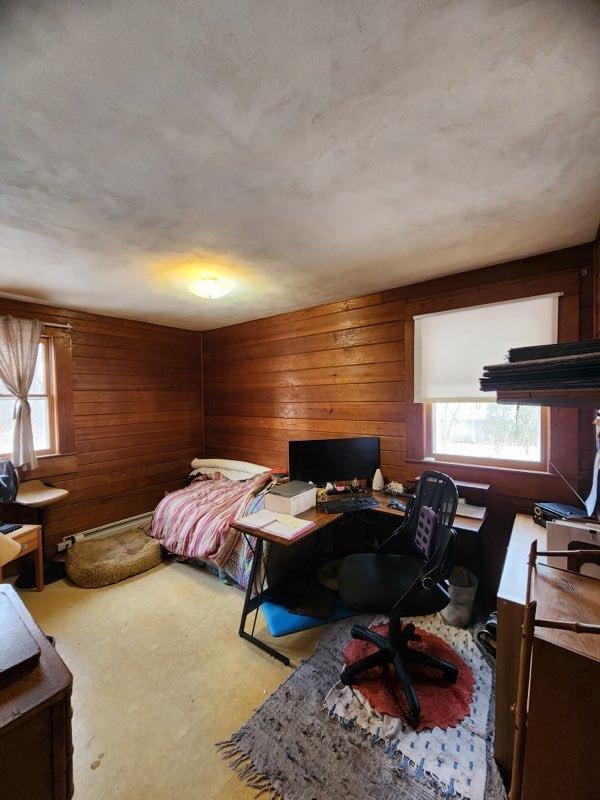 bedroom featuring wood walls