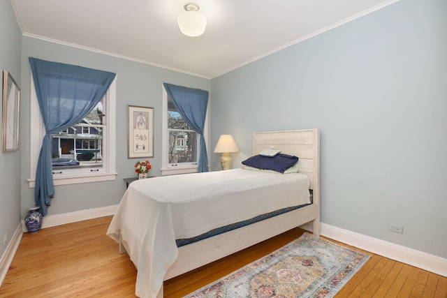 bedroom featuring crown molding, hardwood / wood-style flooring, and baseboards