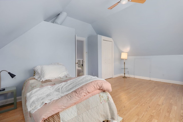 bedroom featuring light wood-style floors, lofted ceiling, ceiling fan, and baseboards