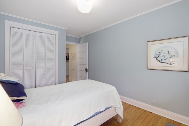 bedroom featuring crown molding, hardwood / wood-style floors, a closet, and baseboards