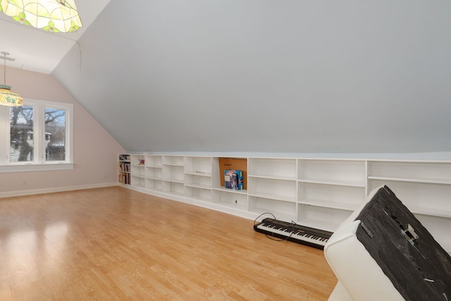 bonus room with vaulted ceiling, light wood-type flooring, and baseboards