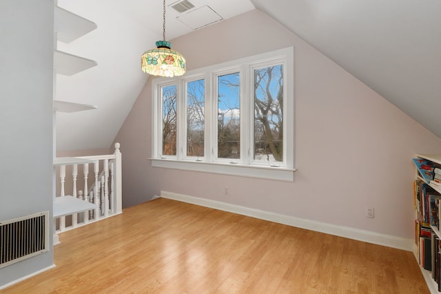 bonus room featuring lofted ceiling, light wood-type flooring, visible vents, and baseboards