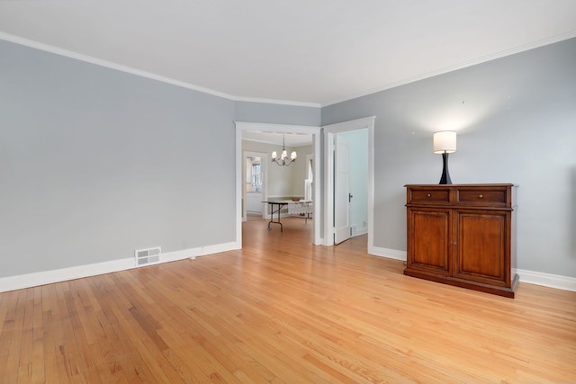 empty room featuring baseboards, ornamental molding, visible vents, and light wood-style floors