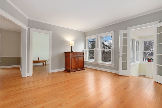 unfurnished room featuring ornamental molding, light wood-type flooring, and baseboards