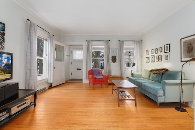 living area featuring light wood-style flooring and ornamental molding