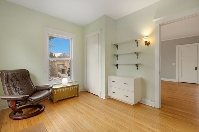 living area featuring light wood-style floors and baseboards