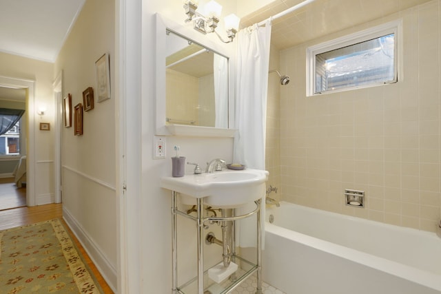 bathroom featuring baseboards, shower / tub combo with curtain, and wood finished floors