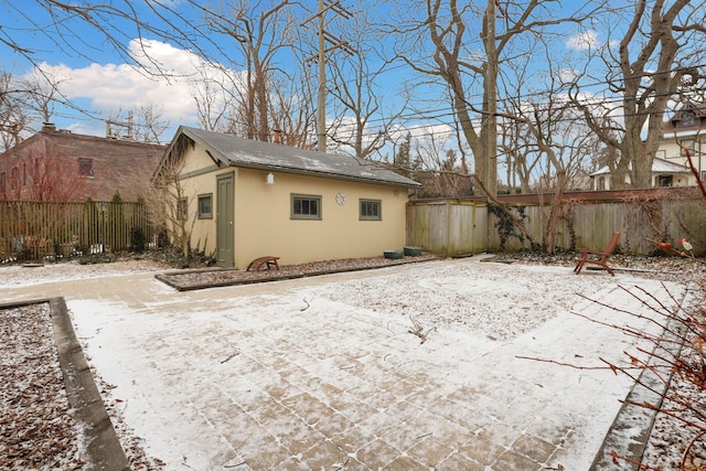 back of house featuring a fenced backyard, an outdoor structure, and stucco siding