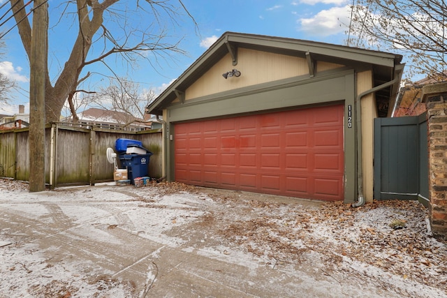 snow covered garage with fence