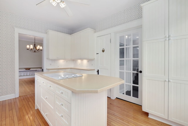 kitchen featuring light wood finished floors, white electric stovetop, and wallpapered walls