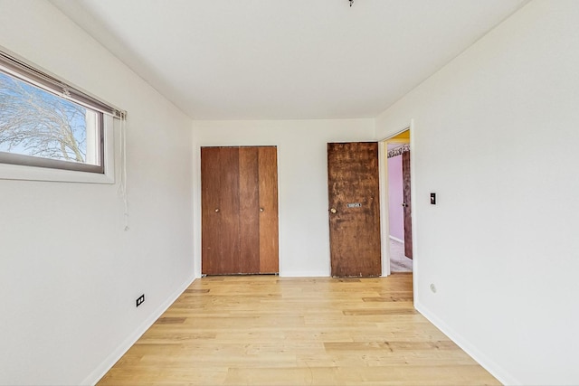 unfurnished bedroom with a closet and light wood-style flooring