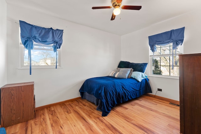 bedroom with visible vents, ceiling fan, baseboards, and wood finished floors