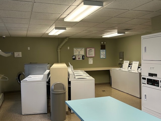 laundry room featuring stacked washer and dryer, a baseboard radiator, and washer and clothes dryer