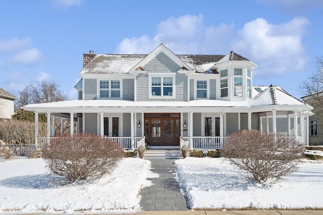 view of front of property featuring french doors, a chimney, and a porch