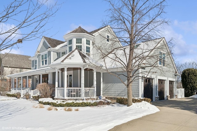 view of front of house featuring a garage, covered porch, and driveway