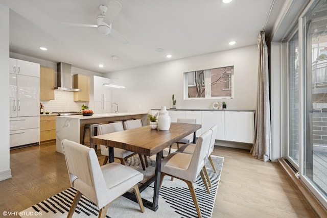 dining area featuring light wood-type flooring, a ceiling fan, and recessed lighting