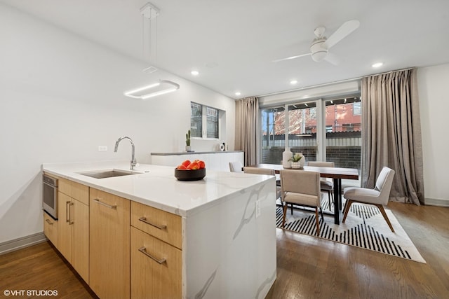 kitchen with dark wood-type flooring, recessed lighting, a sink, and light brown cabinetry