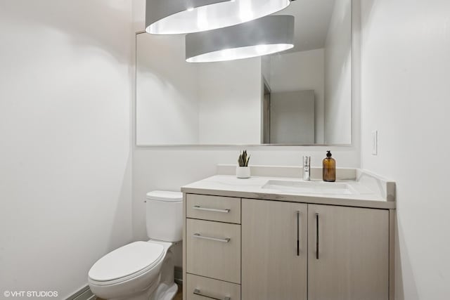 half bathroom featuring vanity and toilet