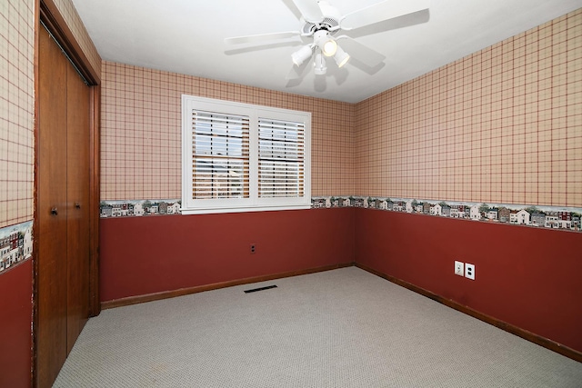 unfurnished room with light carpet, baseboards, visible vents, and a ceiling fan