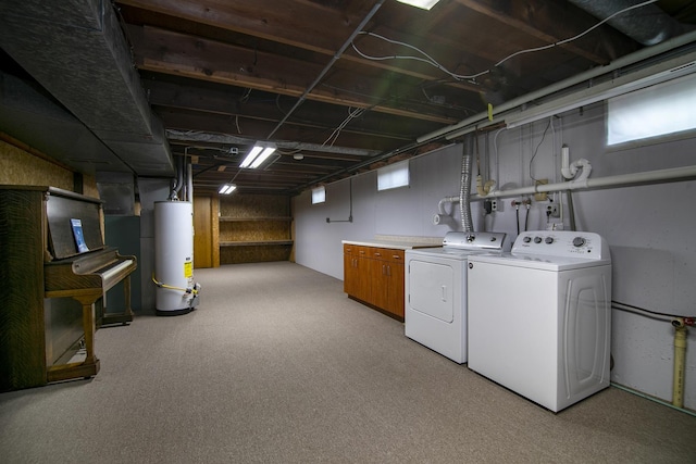 laundry room featuring gas water heater, washing machine and dryer, and cabinet space