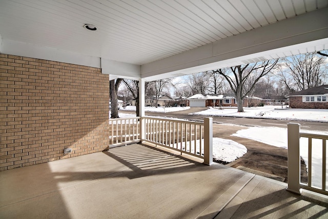 snow covered patio with a porch