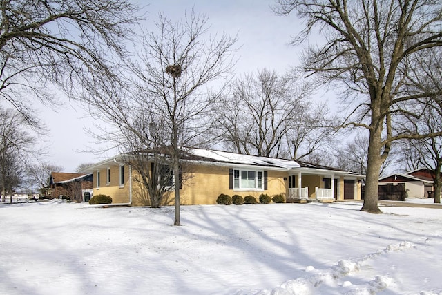 view of front of home featuring a porch, brick siding, and a garage