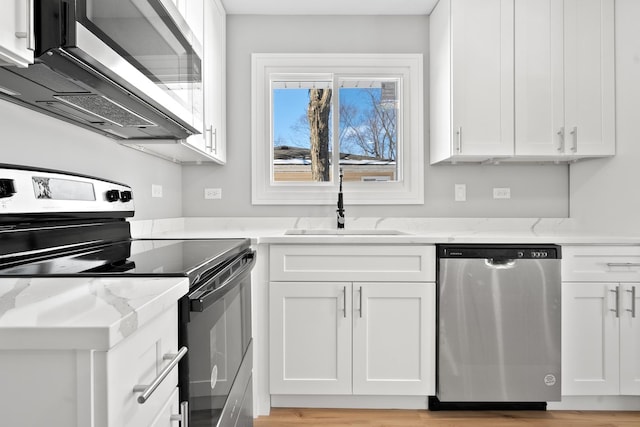 kitchen with white cabinets, light stone countertops, and stainless steel appliances