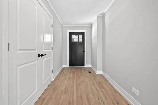 entryway featuring ornamental molding, visible vents, light wood-style floors, and baseboards