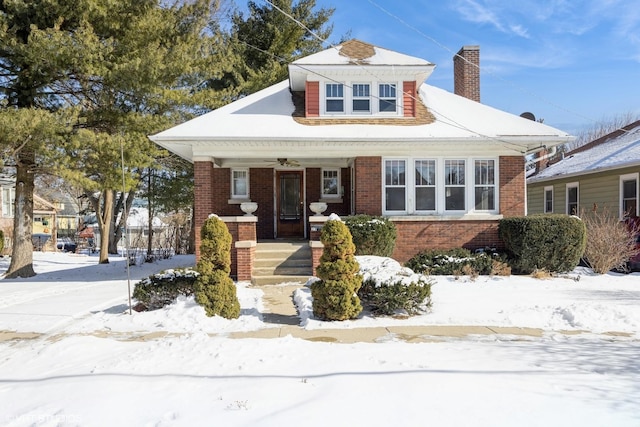 bungalow with brick siding and a chimney