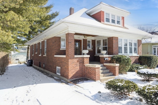 bungalow-style house featuring a chimney and brick siding