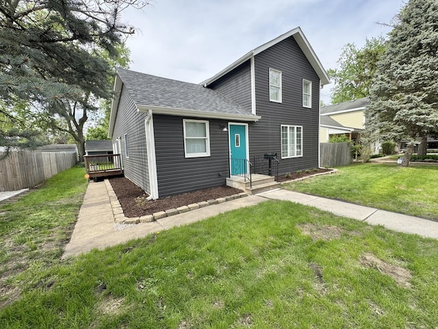 614 E Baltimore St, Wilmington, IL 60481 - traditional-style home with fence, a shingled roof, a front lawn, and a deck