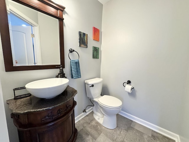614 E Baltimore St, Wilmington, IL 60481 - half bath featuring toilet, baseboards, and vanity