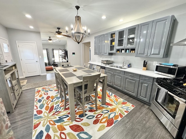 614 E Baltimore St, Wilmington, IL 60481 - kitchen with ceiling fan with notable chandelier, a sink, stainless steel appliances, gray cabinetry, and dark wood-style floors