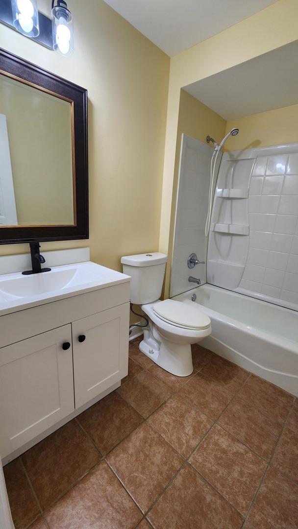 bathroom featuring toilet, shower / tub combination, vanity, and tile patterned floors