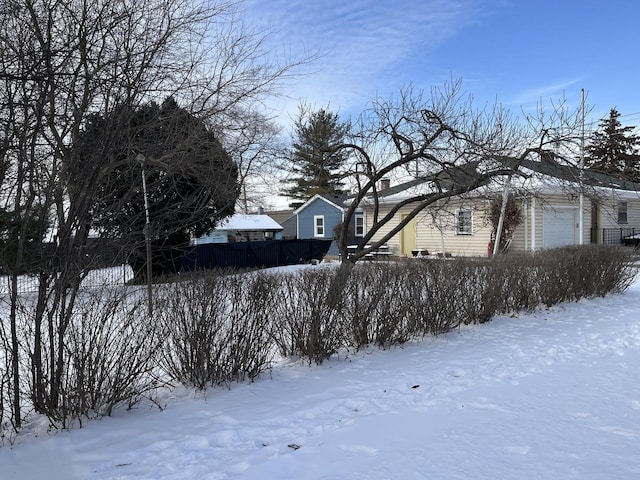 yard layered in snow featuring a garage