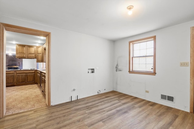 spare room with light wood-style floors and visible vents